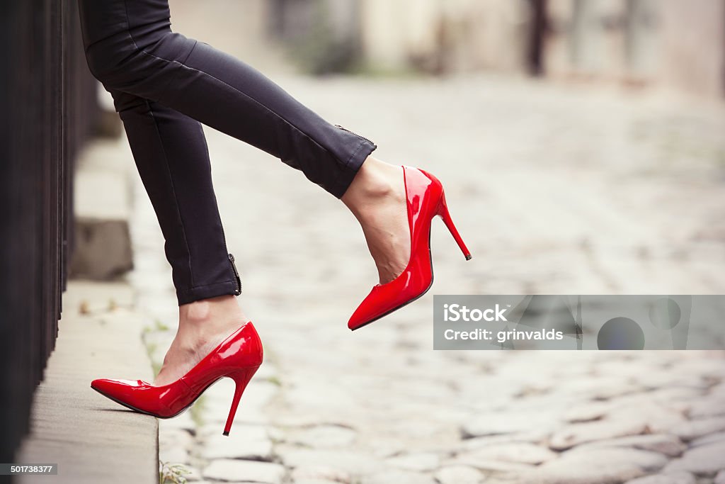 Mujer usando pantalón de cuero negro y rojo y zapatos de tacón de - Foto de stock de Tacones altos libre de derechos