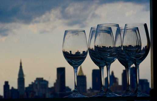 Wine glasses with New York skyline as background