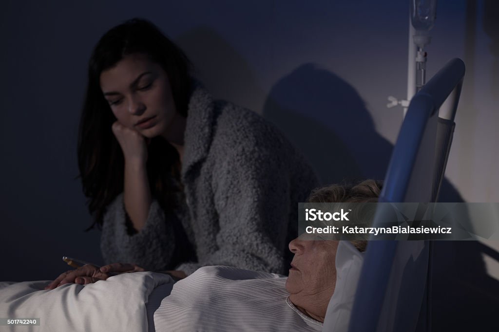 Daughter worrying about sick mother Young woman is visiting and worrying about her sick relative 2015 Stock Photo