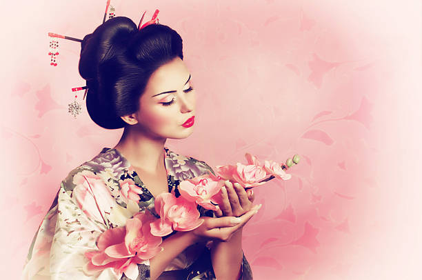 Portrait of a Japanese geisha woman with flower stock photo