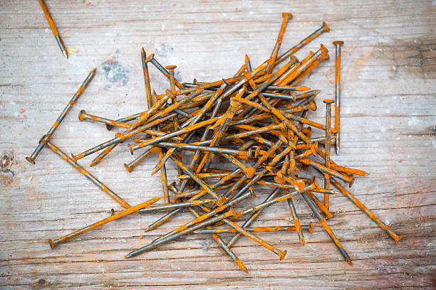 Nails on a Beam Close up of a handful rusty Nails on a beam. rusty nails stock pictures, royalty-free photos & images