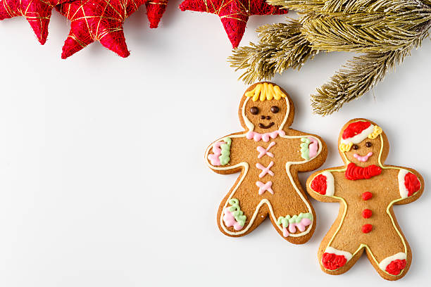 istock Two gingerbread men on white with pine and stars 501746288