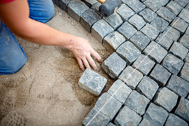 istock industrial construction worker laying cobblestones and stone blocks on pavement 501748750