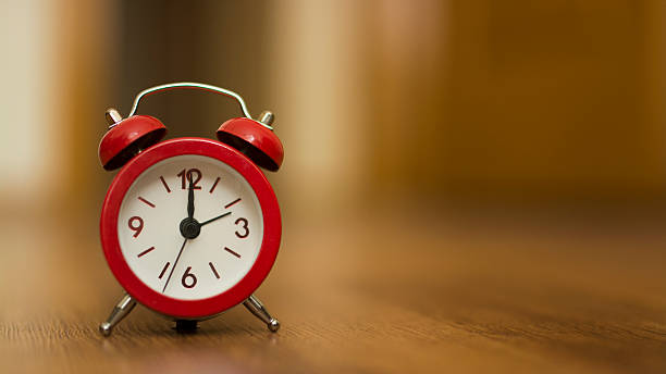 istock red vintage clock on wooden table 501750224