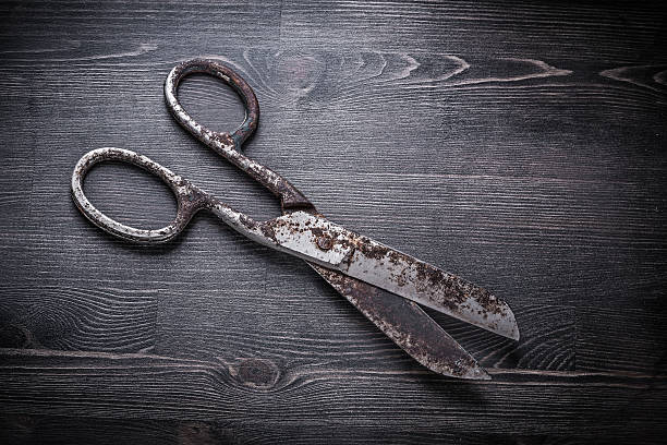 istock Vintage rusty pair of scissors on wooden board 501750228