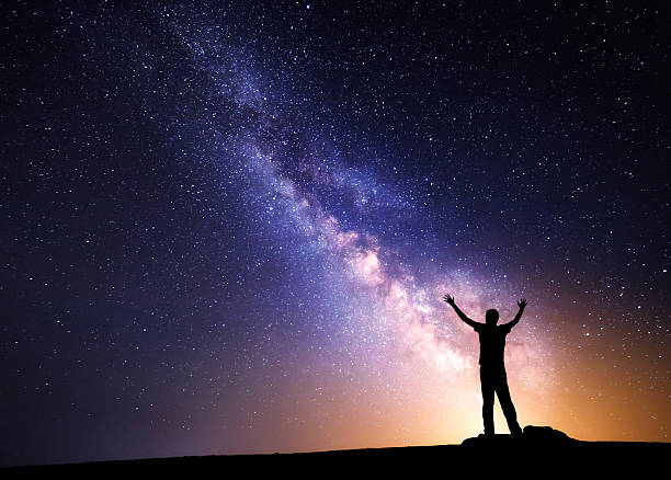 istock Milky Way. Night sky and silhouette of a man 501762518