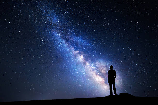 istock Milky Way. Night sky and silhouette of a man 501762578