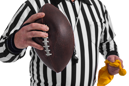 American football player holding the ball in his hands in front of the camera. Concept American football, motivation, black background.
