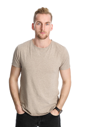 An attractive healthy man standing against a white background wearing a beige t-shirt.