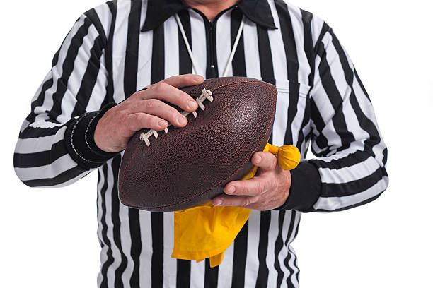 istock Referee squeezing a deflated football and holding penalty flag 501764382