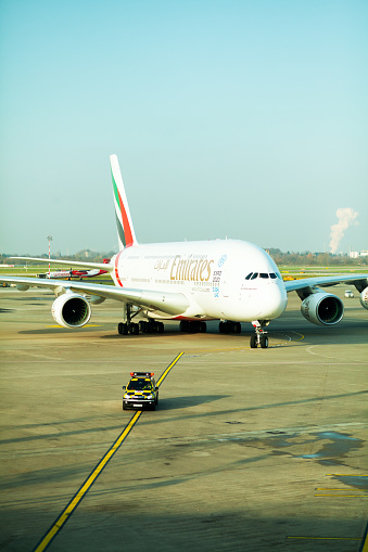Düsseldorf, Germany - December 15, 2015: An Airbus A380 of Emirates is following safety car to parking and boarding position on airport Düsseldorf after landing. Pilots are in cockpit.