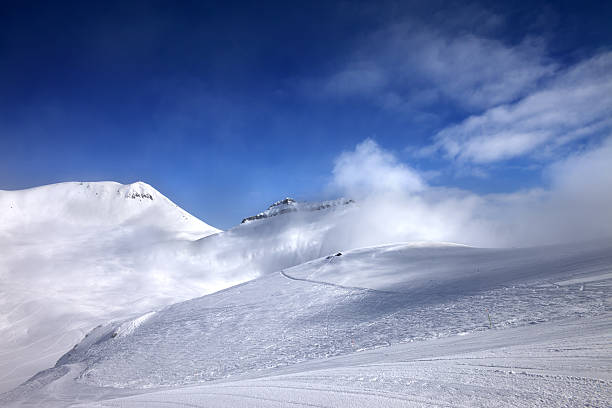 istock Ski slope with snowmobile trail and mountains in mist 501775984