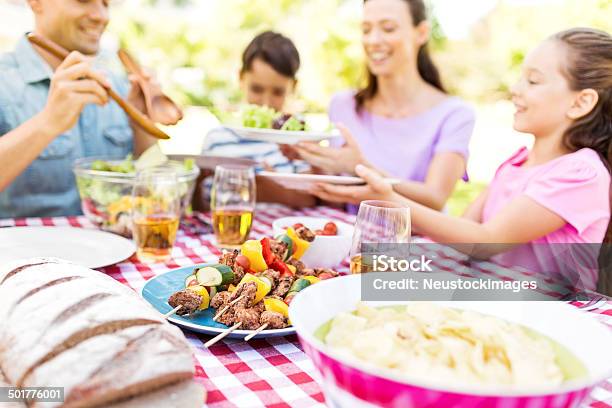 Family Enjoying Meal At Outdoor Table Stock Photo - Download Image Now - Family, Barbecue - Meal, Eating