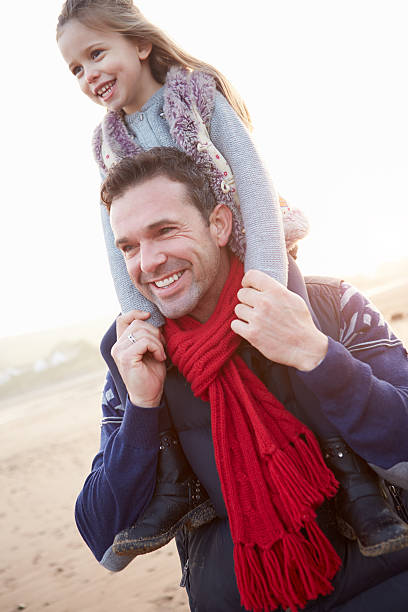 istock Father And Daughter Walking On Winter Beach 501776185