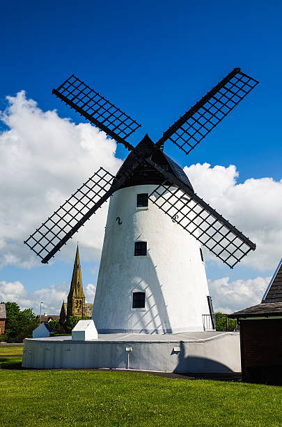 Windmill at Lytham-St-Annes White painted windmill and church at Lytham-St-Annes, Lancashire, England lytham st. annes stock pictures, royalty-free photos & images