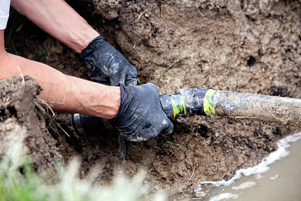 Repairing a Broken Pipe Plumber Repairing a Broken Pipe in a Septic Field sewer drain stock pictures, royalty-free photos & images