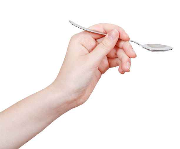 empty teaspoon in hand isolated on white empty teaspoon in hand isolated on white background tsp stock pictures, royalty-free photos & images