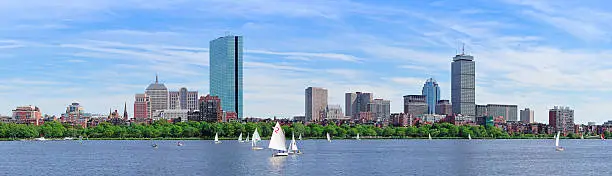 Boston Charles River panorama with urban city skyline skyscrapers and boats with blue sky.