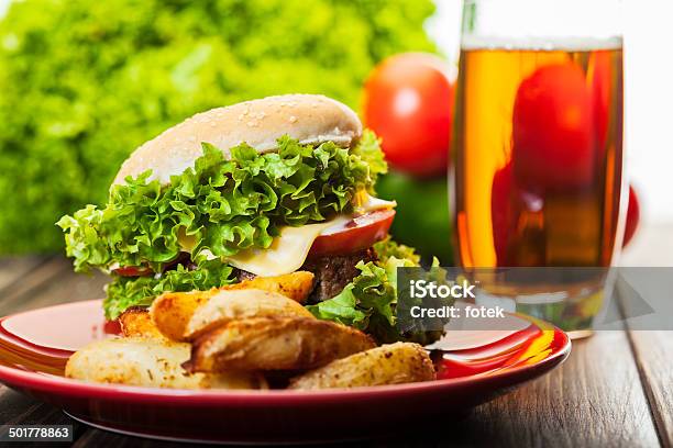 Hamburguesa Con Queso Con Papas Fritas Sobre Una Placa Y Cerveza Foto de stock y más banco de imágenes de Alimento