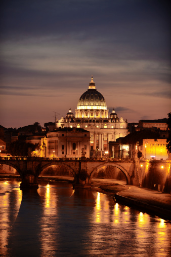 View of the church of St Peter with the Tiber river at night, Rome, Italy