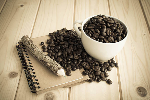 istock coffee cup with coffee beans and notebook on wood table 501784026
