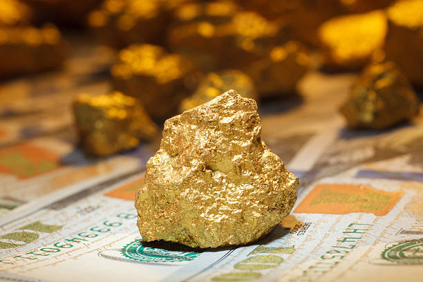 big gold nugget and dollar bills big gold nugget and dollar bills, finance concept ounce stock pictures, royalty-free photos & images