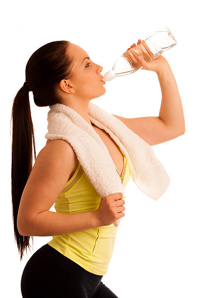 istock woman with towel around neck drinking water after work out 501786784