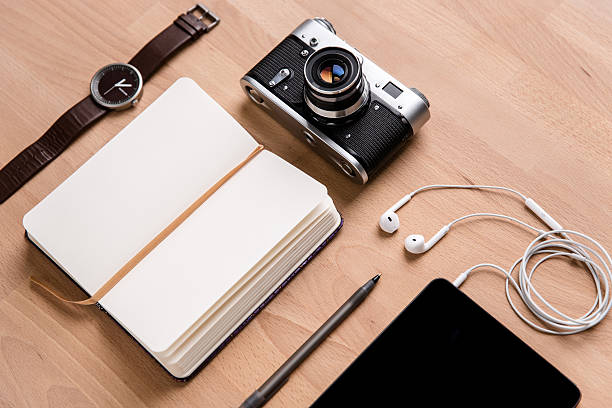 istock Notepad, tablet, earphones, camera watch and pen on wooden table 501789180