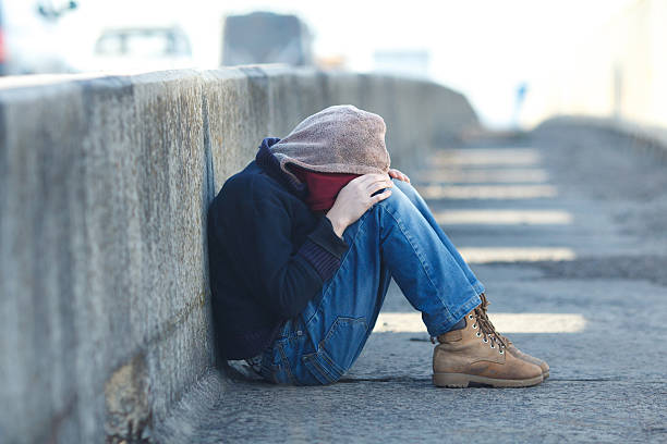 young homeless boy sleeping on the bridge, poverty, city, street