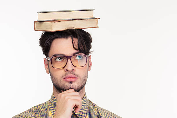 istock Pensive man standing with books on head 501791862