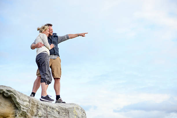 istock Mature couple standing on rocks pointing at view 501793622