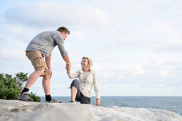 istock Mature man helping woman up onto rocks 501794514