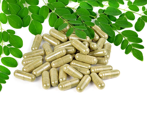 istock herb capsule with green herbal leaf isolated on white background 501796340