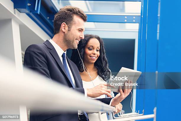Colleagues Using A Digital Tablet Stock Photo - Download Image Now - Computer, Women, Headphones