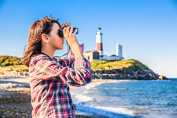 istock Teenage girl exploring ocean with binocular 501797643
