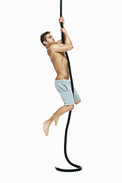 a petto nudo muscoloso uomo arrampicata, con la corda - climbing clambering hanging rope foto e immagini stock