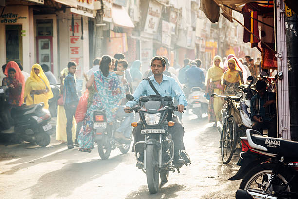 Jodhpur, India - March 14, 2014: People walking along the street, motorbikes and rickshaws in a busy street.