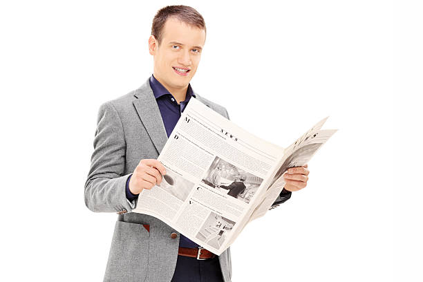 istock Young man holding a newspaper and looking at camera 501799399