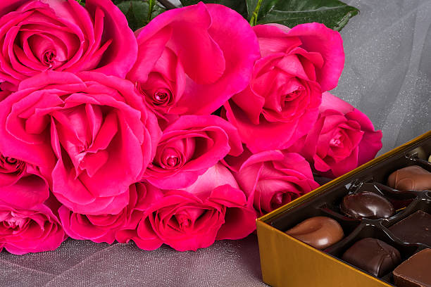 istock Bright Pink Roses and Gourmet Chocolates on Gray Tulle Background 501812024