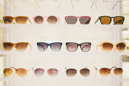Stylish and fashionable sunglasses in a row on the shelf
