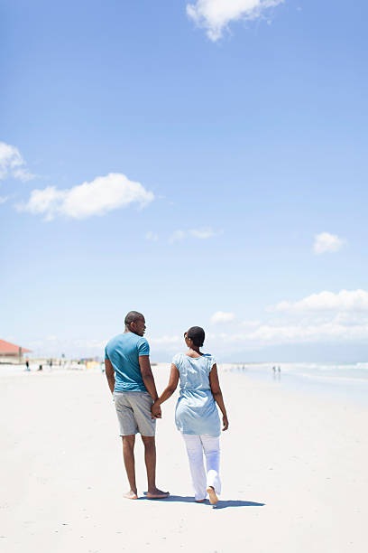istock African couple walking on the beach 501814715