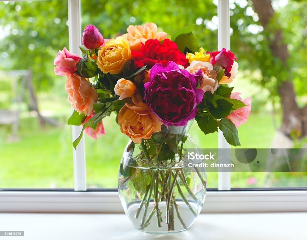 large vase with colorful roses large vase with colorful roses on window sill Vase Stock Photo