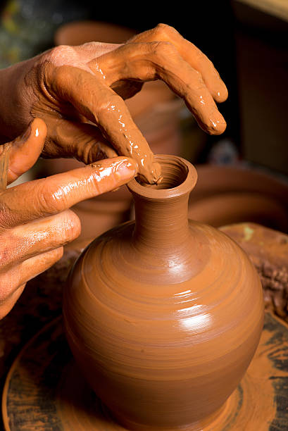 istock hands of a potter, creating an earthen jar 501816449