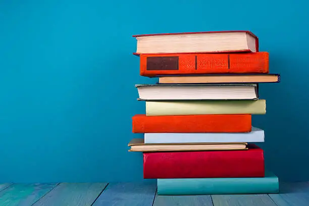 Photo of Stack of colorful books, grungy blue background, free copy space