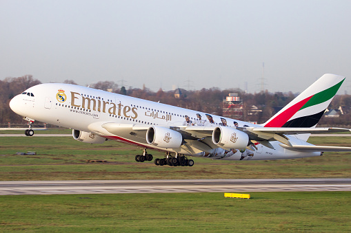 Dusseldorf, Germany - December 17, 2015: Emirates Airbus A380 take off from Dusseldorf airport. Soccer players of Real Madrid are painted on the airplane to show the partnership between Emirates and Real Madrid.