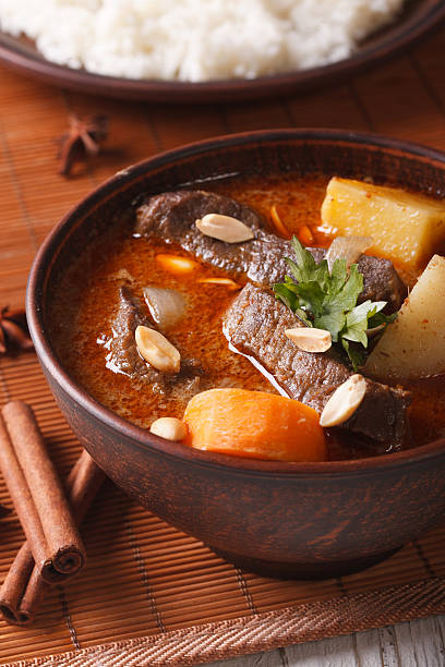 istock Thai beef massaman curry close-up on table and rice. Vertical 501817996