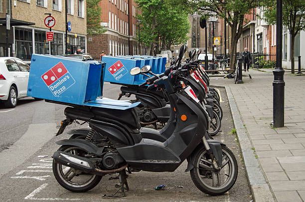 London, England - May 17, 2014:  A row of mopeds operating for the Domino's Pizza takeaway chain parked in Westminster, London.