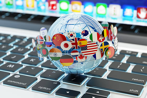 Global internet communication, online messaging and translation concept Speech bubbles with national flags of world countries around blue Earth globe on computer laptop keyboard translation photos stock pictures, royalty-free photos & images