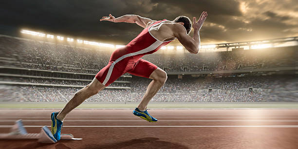 istock Male Sprinter Sprint Starts From Blocks in Athletics Stadium 501821548