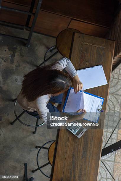 Young Employee Carefully Checking Sales Reports Of Her Company Stock Photo - Download Image Now